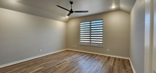 empty room featuring lofted ceiling, a ceiling fan, baseboards, and wood finished floors