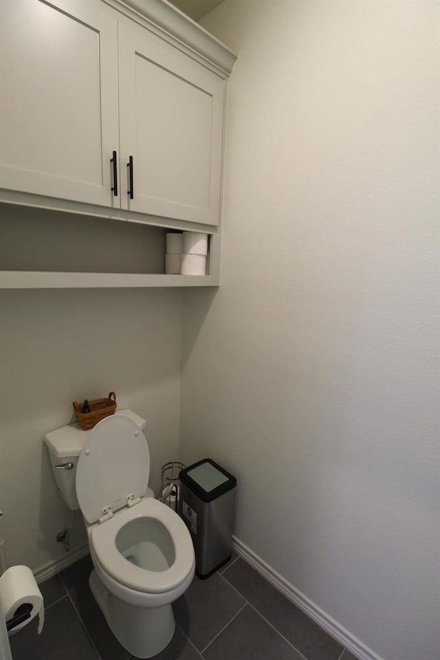 bathroom featuring toilet, tile patterned flooring, and baseboards