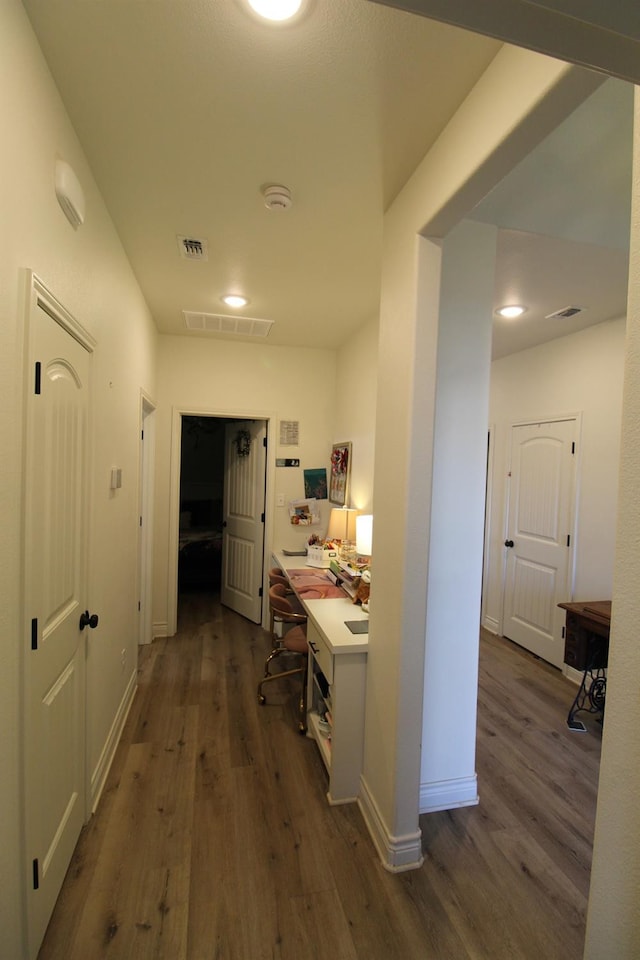 hallway featuring visible vents and dark wood finished floors