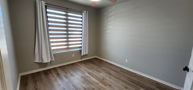 unfurnished room with dark wood-style flooring, a healthy amount of sunlight, and baseboards