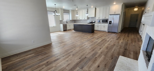 kitchen featuring white cabinets, stainless steel appliances, backsplash, and light countertops