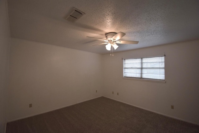 empty room featuring dark carpet, a textured ceiling, and ceiling fan