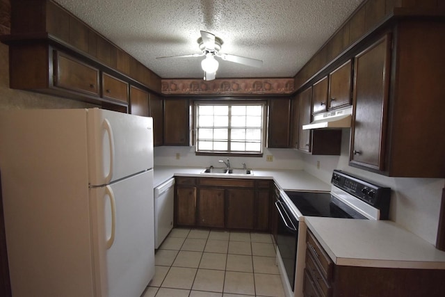 kitchen featuring sink, dark brown cabinets, light tile patterned floors, a textured ceiling, and white appliances