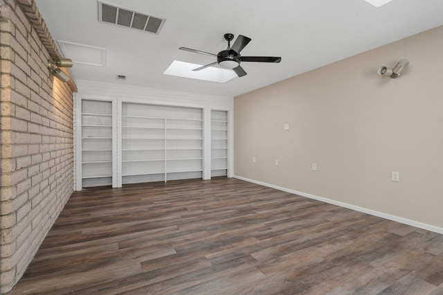 unfurnished bedroom with ceiling fan, brick wall, and dark hardwood / wood-style floors