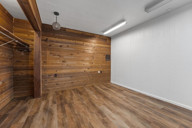 unfurnished room with dark hardwood / wood-style floors and wood walls