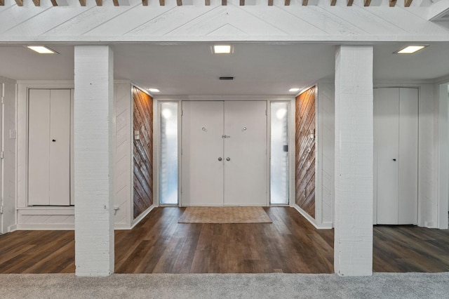 foyer entrance featuring dark colored carpet