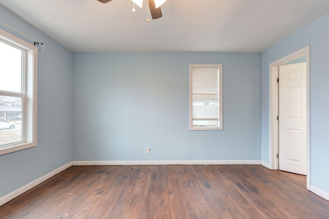 empty room with ceiling fan and dark hardwood / wood-style flooring