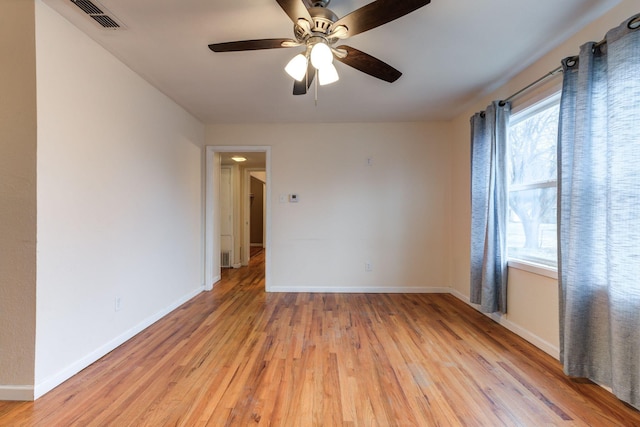 empty room with ceiling fan and light hardwood / wood-style flooring