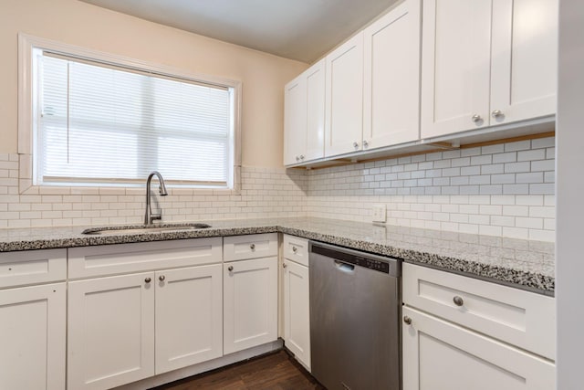 kitchen with stainless steel dishwasher, light stone countertops, sink, and white cabinets