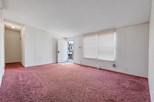 carpeted spare room with a textured ceiling