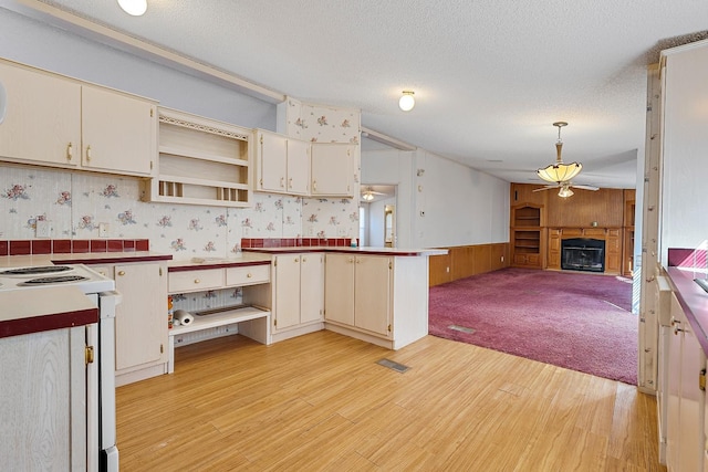 kitchen featuring pendant lighting, cream cabinets, ceiling fan, and white range with electric cooktop