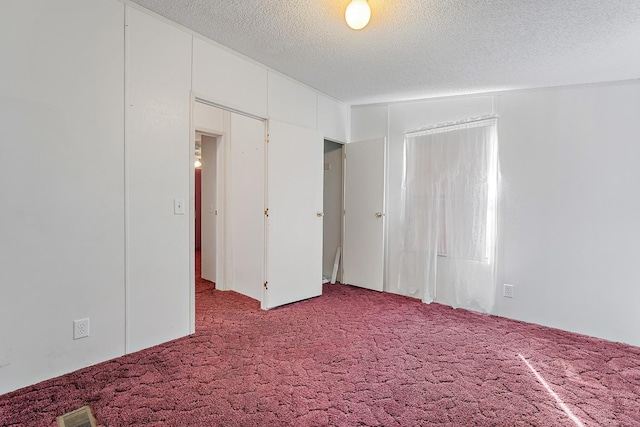 unfurnished bedroom with carpet floors and a textured ceiling