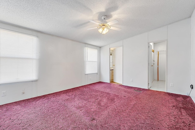 unfurnished bedroom featuring ceiling fan, light carpet, and a textured ceiling