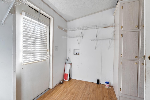 washroom featuring washer hookup, light hardwood / wood-style floors, and a textured ceiling