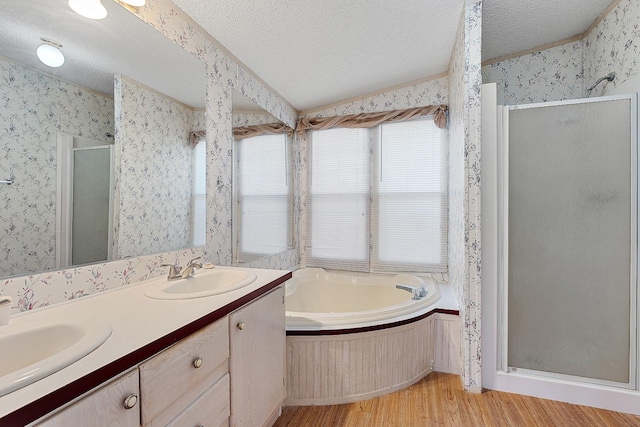 bathroom with vanity, hardwood / wood-style floors, shower with separate bathtub, and a textured ceiling