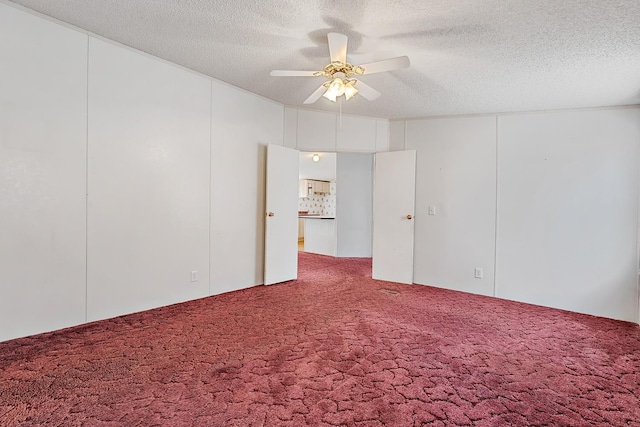 carpeted spare room featuring ceiling fan and a textured ceiling