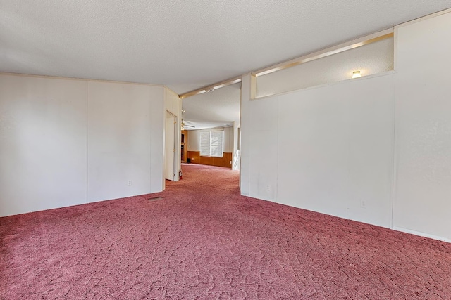 empty room with carpet floors and a textured ceiling