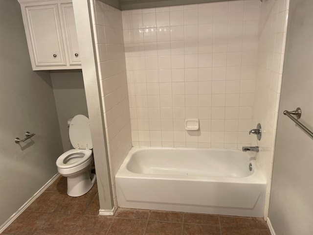 bathroom featuring tiled shower / bath, toilet, and tile patterned flooring