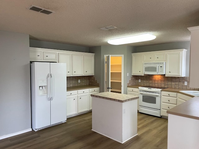 kitchen with a kitchen island, white cabinetry, backsplash, dark wood-type flooring, and white appliances