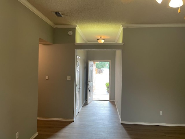 entryway with crown molding, wood-type flooring, and a textured ceiling