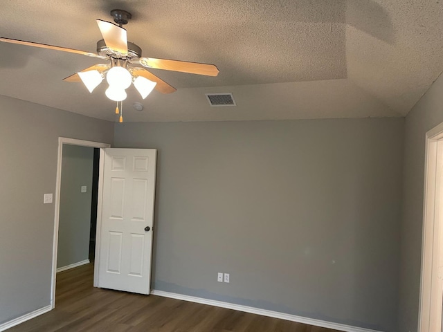 spare room with dark hardwood / wood-style flooring, a textured ceiling, and ceiling fan