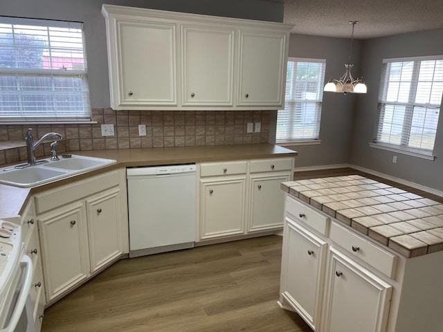 kitchen with white cabinetry, hanging light fixtures, sink, and dishwasher