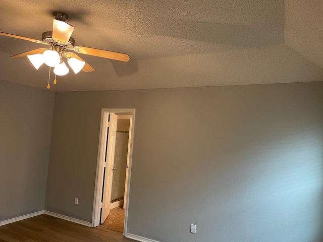 spare room with wood-type flooring, ceiling fan, and a textured ceiling