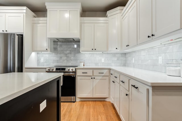 kitchen with white cabinetry, appliances with stainless steel finishes, backsplash, and light hardwood / wood-style floors