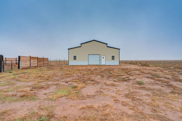 exterior space with a garage and a rural view