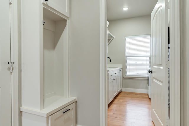 mudroom featuring sink and light wood-type flooring