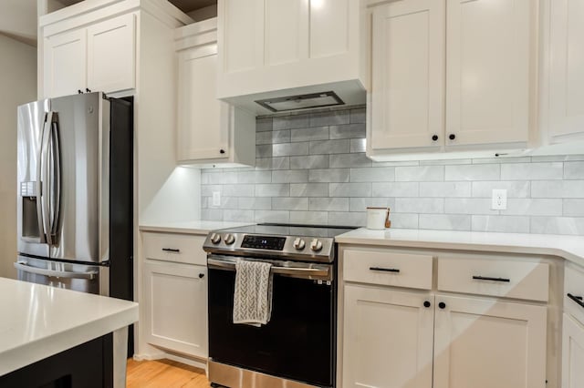 kitchen with stainless steel appliances, white cabinetry, and custom range hood