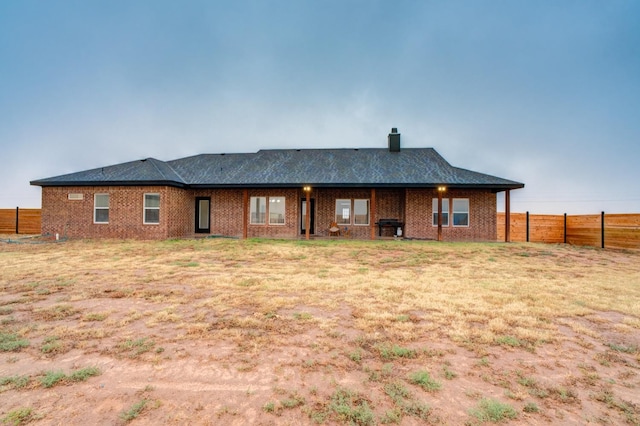 rear view of house featuring a lawn