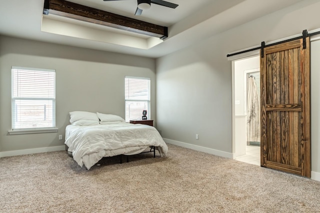 bedroom featuring beamed ceiling, a barn door, light carpet, and multiple windows