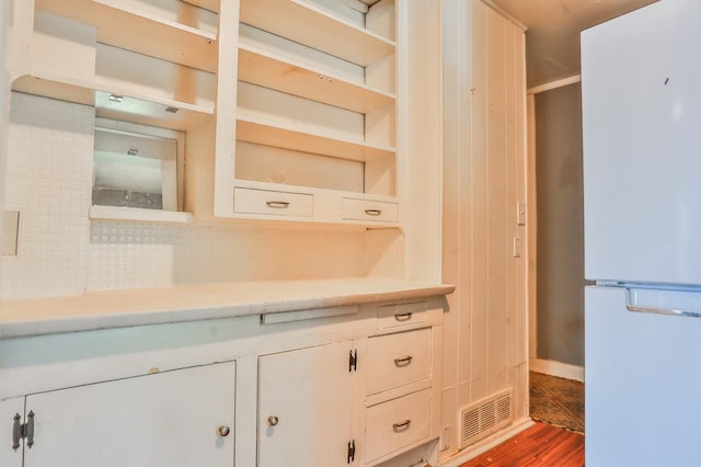 interior space featuring hardwood / wood-style flooring, white cabinets, and white fridge