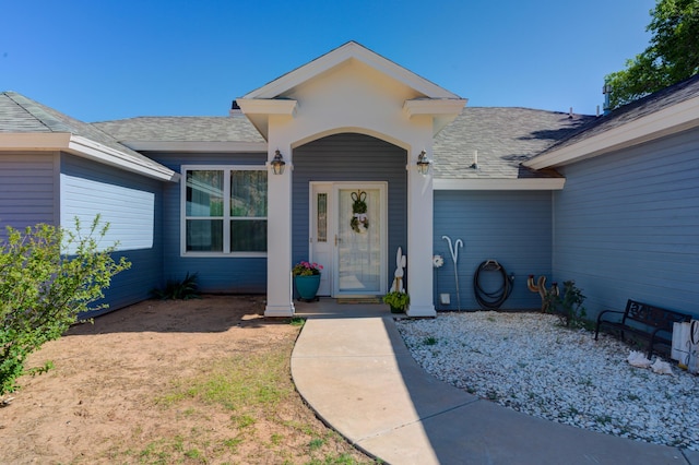 doorway to property featuring a shingled roof