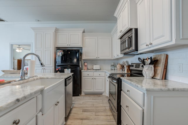 kitchen featuring a ceiling fan, appliances with stainless steel finishes, white cabinetry, and light wood-type flooring