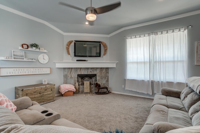 living area featuring baseboards, a ceiling fan, carpet flooring, and crown molding