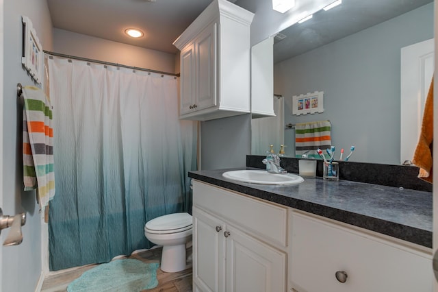 bathroom with a shower with curtain, toilet, visible vents, wood finished floors, and vanity