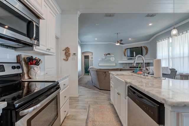 kitchen featuring visible vents, ornamental molding, a ceiling fan, and stainless steel appliances