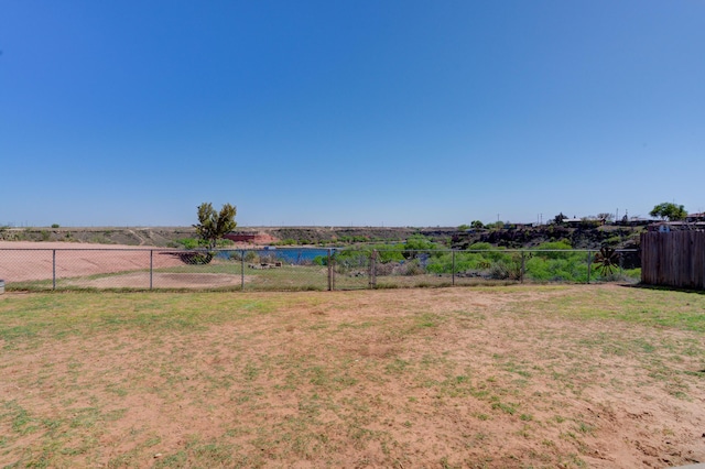 view of yard with a water view and fence