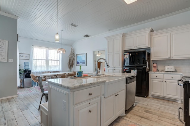 kitchen with stainless steel dishwasher, visible vents, freestanding refrigerator, light wood-style floors, and white cabinetry