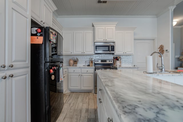 kitchen featuring ornamental molding, appliances with stainless steel finishes, a sink, and white cabinetry