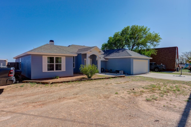 ranch-style house with a shingled roof, driveway, and a chimney