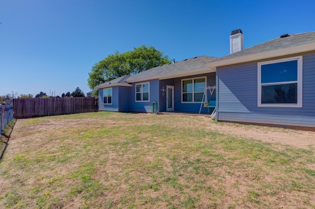 view of front of property with a chimney, fence, and a front yard