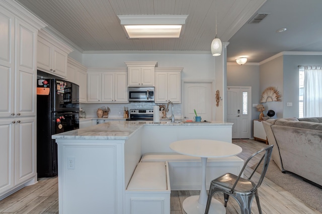 kitchen with backsplash, visible vents, light wood-style flooring, appliances with stainless steel finishes, and open floor plan