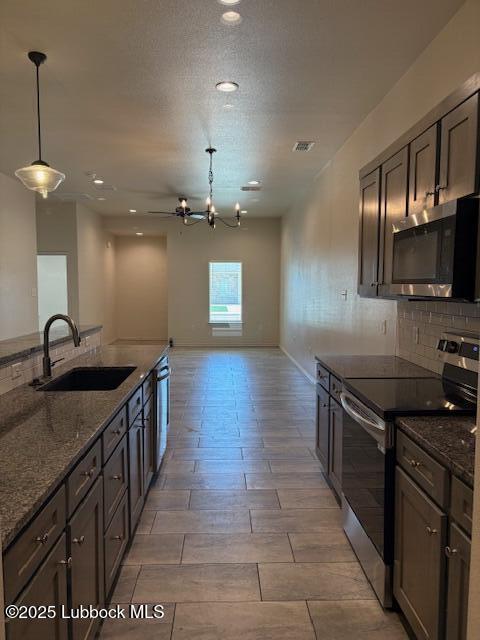 2612 136th St, Lubbock, TX 79423 - kitchen with stainless steel appliances, a sink, tasteful backsplash, dark stone countertops, and recessed lighting