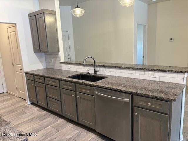2612 136th St, Lubbock, TX 79423 - kitchen featuring dishwasher, a sink, dark stone countertops, and backsplash