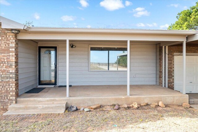 entrance to property with a garage and a porch