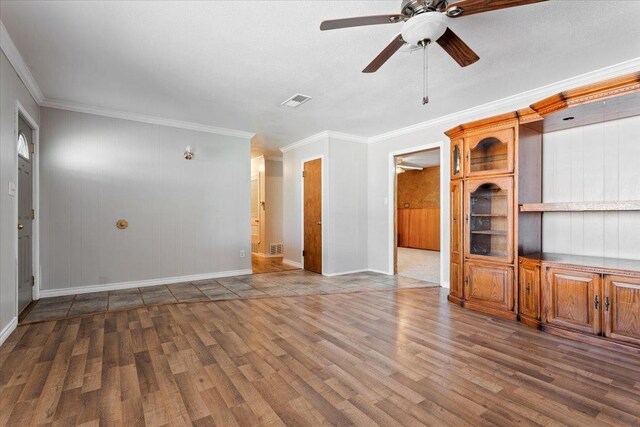 unfurnished living room with dark wood-type flooring, ceiling fan, and crown molding