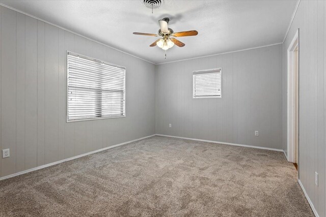 spare room with light carpet, ornamental molding, and ceiling fan